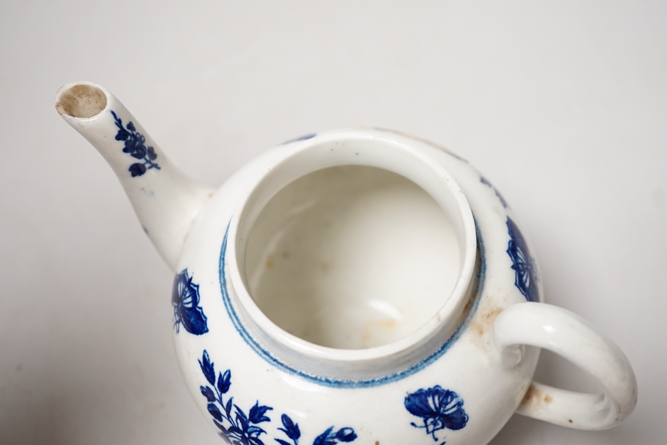 A Liverpool porcelain blue and white sauceboat and a Worcester teapot. Tallest 12cm